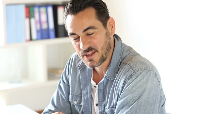 Photo of a man talking in an office | Photo: Shutterstock.com